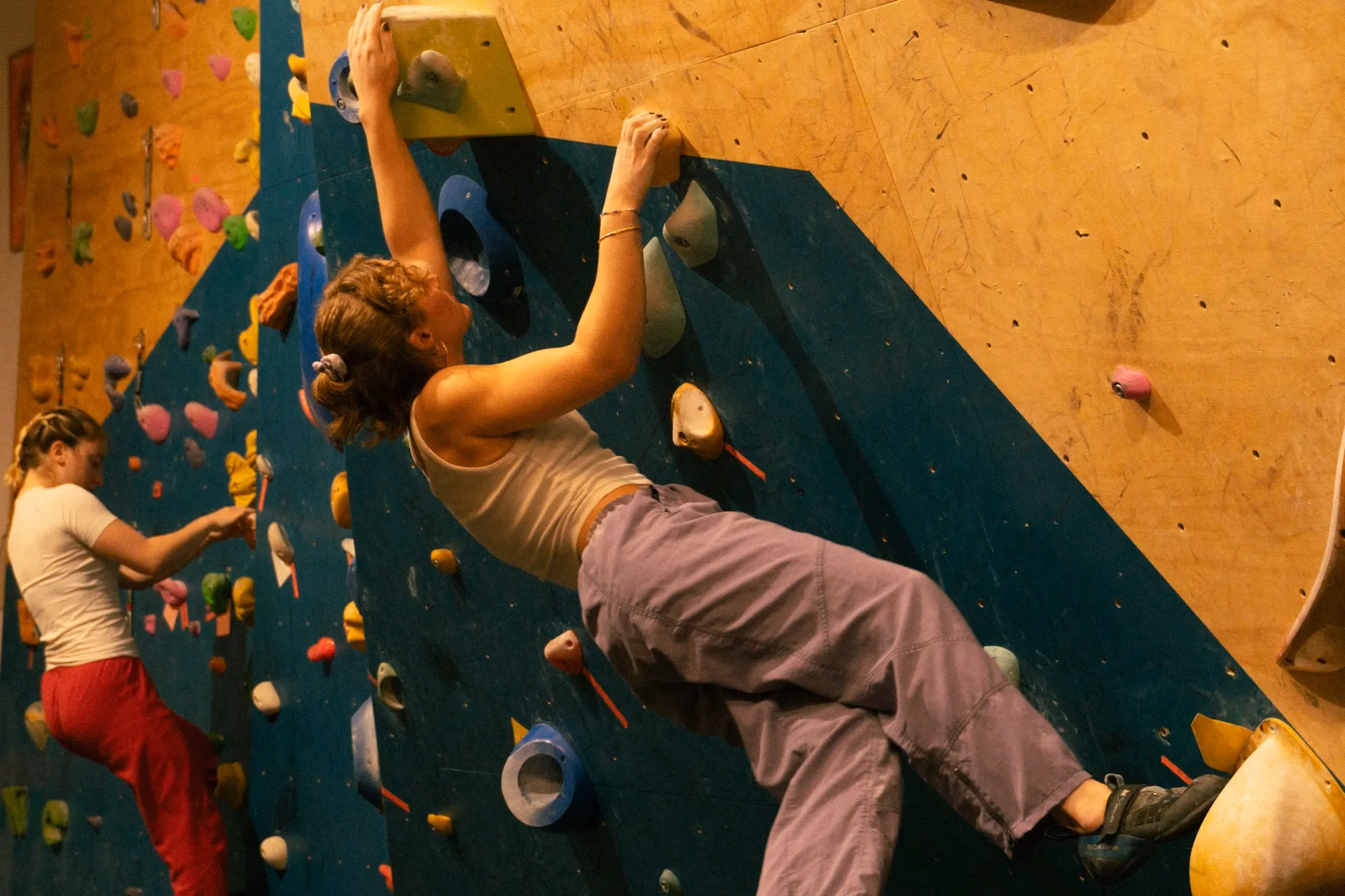 Climber in movimento su una parete blu e legno