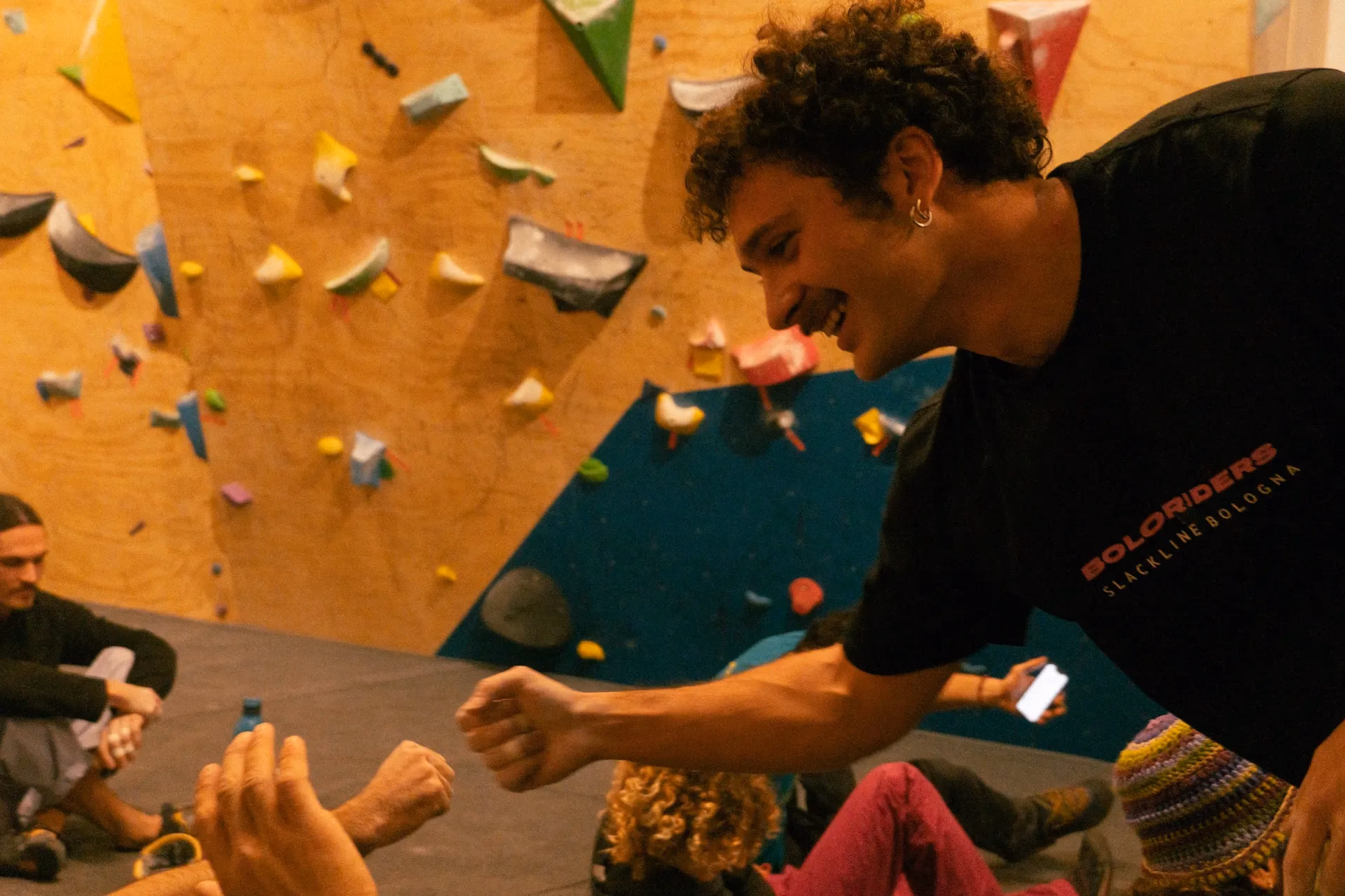 Due persone che si allenano sulla parete con prese colorate